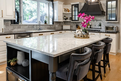 Inspiration for a large transitional u-shaped light wood floor and beige floor eat-in kitchen remodel in Chicago with a drop-in sink, raised-panel cabinets, white cabinets, quartz countertops, gray backsplash, ceramic backsplash, paneled appliances, an island and multicolored countertops