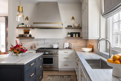 Example of a transitional l-shaped dark wood floor and brown floor kitchen design in Detroit with an undermount sink, shaker cabinets, white cabinets, gray backsplash, stone slab backsplash, stainless steel appliances, an island and gray countertops