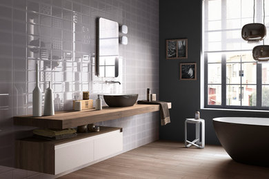 Photo of a contemporary bathroom in Denver with a vessel sink, a freestanding tub, grey walls and medium hardwood floors.