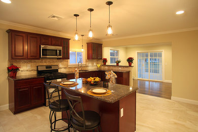 Example of a classic kitchen design in New York with raised-panel cabinets, dark wood cabinets, granite countertops, beige backsplash, ceramic backsplash, stainless steel appliances and an island
