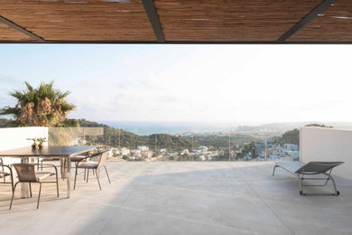 Ejemplo de terraza moderna extra grande sin cubierta en azotea con privacidad y barandilla de vidrio