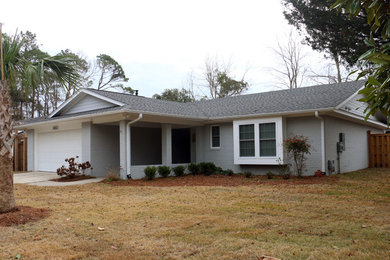 Example of a mid-sized beach style green one-story brick gable roof design in Other