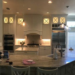 Mid-sized transitional kitchen pantry photos - Kitchen pantry - mid-sized transitional l-shaped dark wood floor and brown floor kitchen pantry idea in Dallas with a farmhouse sink, glass-front cabinets, white cabinets, granite countertops, gray backsplash, ceramic backsplash, stainless steel appliances and an island
