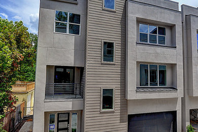 Minimalist gray three-story stucco exterior home photo in Houston