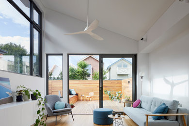 Mid-sized contemporary family room in Melbourne with white walls and light hardwood floors.