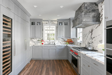 Inspiration for a timeless u-shaped porcelain tile and brown floor enclosed kitchen remodel in Houston with an undermount sink, recessed-panel cabinets, gray cabinets, quartz countertops, white backsplash, quartz backsplash, paneled appliances, no island and white countertops