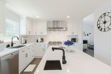 Example of a mid-sized minimalist l-shaped ceramic tile and brown floor open concept kitchen design with an undermount sink, shaker cabinets, white cabinets, quartz countertops, white backsplash, subway tile backsplash, stainless steel appliances, an island and white countertops