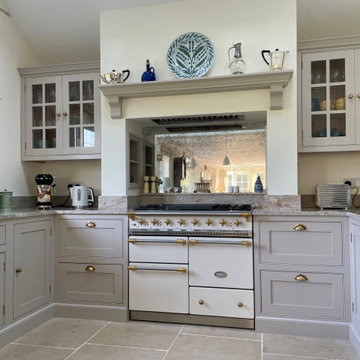 Light grey traditional handmade kitchen with glazed bar wall cabinets and mantel