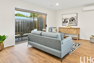 Photo of a small contemporary open plan living room in Other with white walls and laminate floors.