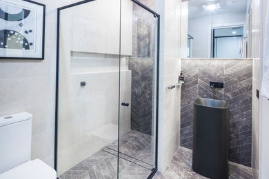 Design ideas for a mid-sized contemporary 3/4 bathroom in Canberra - Queanbeyan with a corner shower and grey floor.