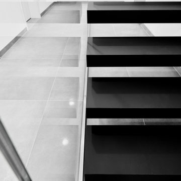 Kragarmtreppe in matt schwarz mit Weißglas