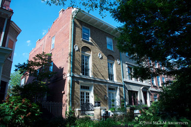 Large elegant beige three-story brick exterior home photo in DC Metro with a shed roof