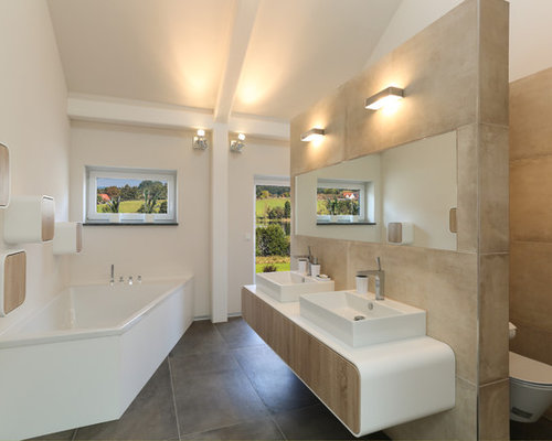 Badezimmer mit Eckbadewanne und hellen Holzschränken: DesignIdeen 