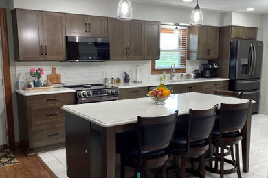 Example of a mid-sized trendy single-wall eat-in kitchen design in Other with brown cabinets, quartz countertops, white backsplash, ceramic backsplash and an island