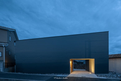 Modelo de fachada de casa gris y gris minimalista de tamaño medio de dos plantas con revestimiento de metal, tejado de un solo tendido y tejado de metal