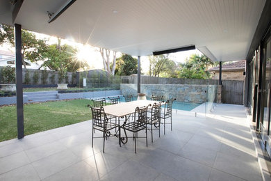 This is an example of a small contemporary backyard patio in Sydney with natural stone pavers.