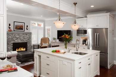 Inspiration for a large transitional u-shaped medium tone wood floor and brown floor eat-in kitchen remodel in Philadelphia with an undermount sink, beaded inset cabinets, white cabinets, marble countertops, white backsplash, subway tile backsplash, stainless steel appliances and an island