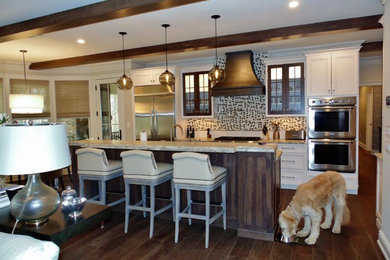 Eat-in kitchen - large shabby-chic style galley medium tone wood floor eat-in kitchen idea in New York with a farmhouse sink, recessed-panel cabinets, white cabinets, granite countertops, multicolored backsplash, mosaic tile backsplash, stainless steel appliances and an island