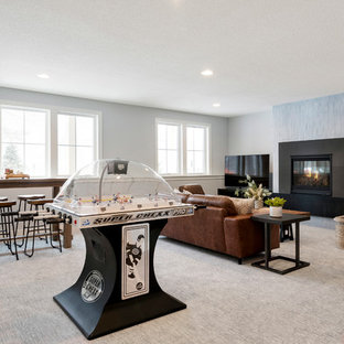 ミネアポリスの中サイズのモダンスタイルのおしゃれな地下室 (半地下 (窓あり) 、グレーの壁、カーペット敷き、横長型暖炉、コンクリートの暖炉まわり、グレーの床) の写真