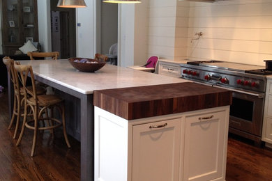 Inspiration for a timeless dark wood floor kitchen remodel in Other with a farmhouse sink, recessed-panel cabinets, white cabinets, marble countertops, stainless steel appliances and an island