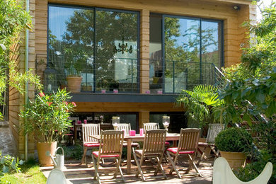 Cette image montre une terrasse arrière design de taille moyenne avec aucune couverture.