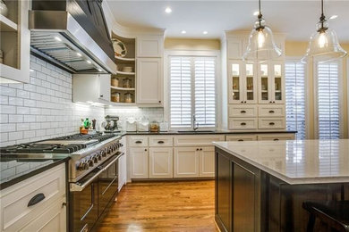 Mid-sized farmhouse u-shaped light wood floor eat-in kitchen photo in Dallas with an undermount sink, shaker cabinets, black cabinets, quartz countertops, black backsplash, ceramic backsplash and black appliances