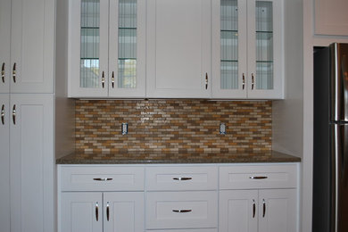 Small trendy l-shaped eat-in kitchen photo in Miami with glass-front cabinets, white cabinets, marble countertops, multicolored backsplash and mosaic tile backsplash