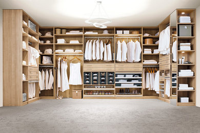 Design ideas for a large contemporary gender-neutral walk-in wardrobe in Cologne with open cabinets, carpet and grey floor.
