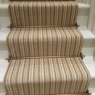 This is an example of a medium sized traditional carpeted u-shaped wood railing staircase in London with carpeted risers.