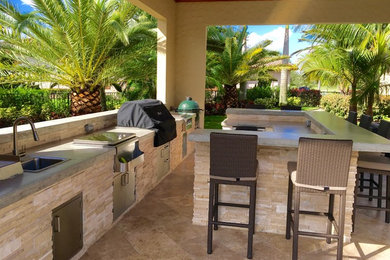 Large tropical backyard patio in Phoenix with an outdoor kitchen, natural stone pavers and a gazebo/cabana.
