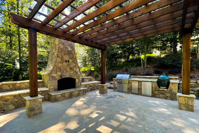 Inspiration for a huge rustic backyard stone patio remodel in Atlanta with a fireplace and a pergola