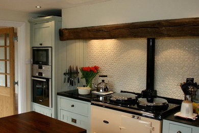 Mid-sized elegant galley eat-in kitchen photo in Denver with recessed-panel cabinets, blue cabinets, wood countertops, beige backsplash, ceramic backsplash, colored appliances and an island