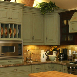 Große Landhaus Küche in L-Form mit Vorratsschrank, Landhausspüle, profilierten Schrankfronten, grünen Schränken, Granit-Arbeitsplatte, Küchenrückwand in Orange, Rückwand aus Metrofliesen, Küchengeräten aus Edelstahl, Keramikboden und Kücheninsel in Orange County