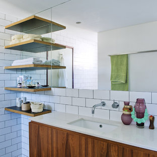 Foto di una stanza da bagno moderna con piastrelle in ceramica, lavabo sottopiano, piastrelle bianche e pareti bianche