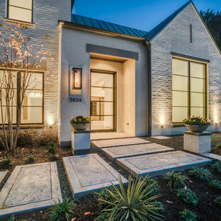 Inspiration for a large modern white two-story brick exterior home remodel in New Orleans with a metal roof