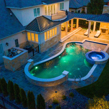 Naperville, IL freeform swimming pool with hot tub, large sunshelf, glass tile