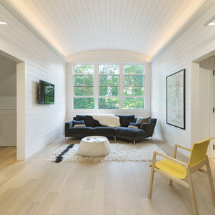 Inspiration for a farmhouse enclosed light wood floor family room remodel in Boston with white walls and a wall-mounted tv