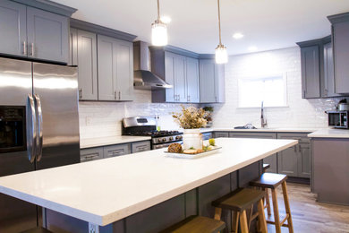 Inspiration for a country kitchen remodel in Los Angeles with shaker cabinets, gray cabinets, quartz countertops, white backsplash, an island and white countertops