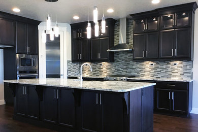 Kitchen pantry - large contemporary l-shaped dark wood floor and brown floor kitchen pantry idea in Tampa with a double-bowl sink, flat-panel cabinets, black cabinets, granite countertops, multicolored backsplash, glass tile backsplash, stainless steel appliances, an island and white countertops