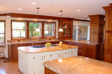 Inspiration for a large traditional u-shaped eat-in kitchen in Salt Lake City with a double-bowl sink, beaded inset cabinets, medium wood cabinets, quartzite benchtops, panelled appliances, light hardwood floors and multiple islands.
