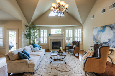 This is an example of a large transitional open concept family room in Houston with beige walls, medium hardwood floors, a standard fireplace, a tile fireplace surround and brown floor.