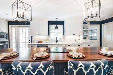 Inspiration for a mid-sized coastal galley dark wood floor and brown floor open concept kitchen remodel in Other with a single-bowl sink, flat-panel cabinets, blue cabinets, quartz countertops, gray backsplash, marble backsplash, stainless steel appliances, an island and gray countertops