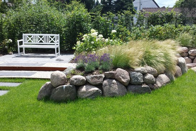 Mittelgroße Maritime Gartenmauer im Sommer mit direkter Sonneneinstrahlung und Natursteinplatten in Düsseldorf