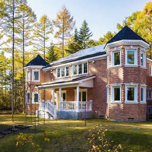 東京都下のトラディショナルスタイルのおしゃれな二階建ての家 (レンガサイディング、赤い外壁、戸建、板屋根) の写真