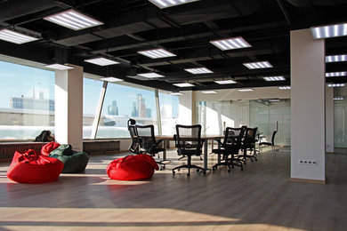 Стильный дизайн: большое рабочее место в современном стиле с белыми стенами, полом из ламината, отдельно стоящим рабочим столом и бежевым полом - последний тренд