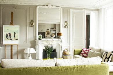 Cette image montre un salon bohème de taille moyenne et ouvert avec un mur blanc, parquet clair, une cheminée standard, un manteau de cheminée en pierre, aucun téléviseur et un sol marron.