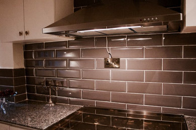 Inspiration for a mid-sized contemporary l-shaped kitchen remodel in Other with white cabinets, granite countertops, gray backsplash, ceramic backsplash, multicolored countertops, flat-panel cabinets, stainless steel appliances and no island