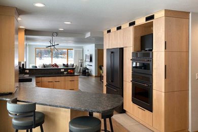 Example of a minimalist galley vinyl floor eat-in kitchen design in Other with an undermount sink, flat-panel cabinets, light wood cabinets, granite countertops, gray backsplash, ceramic backsplash, black appliances, a peninsula and gray countertops