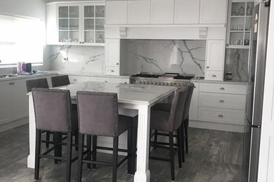 This is an example of a large traditional kitchen in Sydney with shaker cabinets, white cabinets and quartz benchtops.