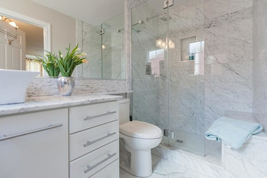 Doorless shower - mid-sized transitional master white tile and stone tile marble floor and white floor doorless shower idea in Other with flat-panel cabinets, white walls, a vessel sink, marble countertops, white cabinets, a one-piece toilet and a hinged shower door